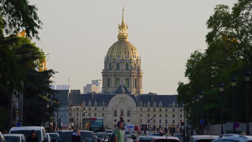 Heavy vehicle and foot traffic near an old domed building