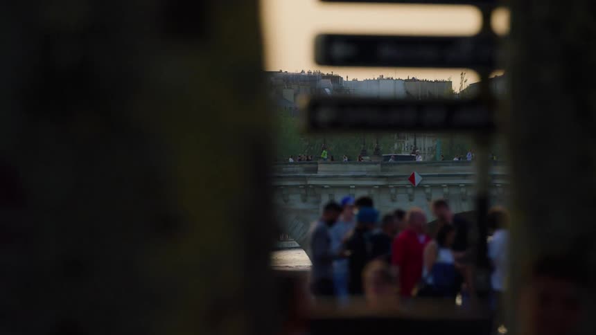 Crowd of people on bridges over a lake canal in the middle of a city in france in the late afternoon