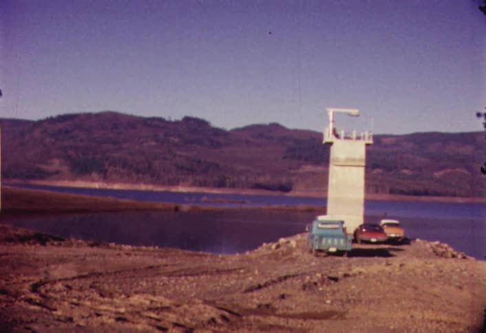 Three vintage vehicles sitting lakeside
