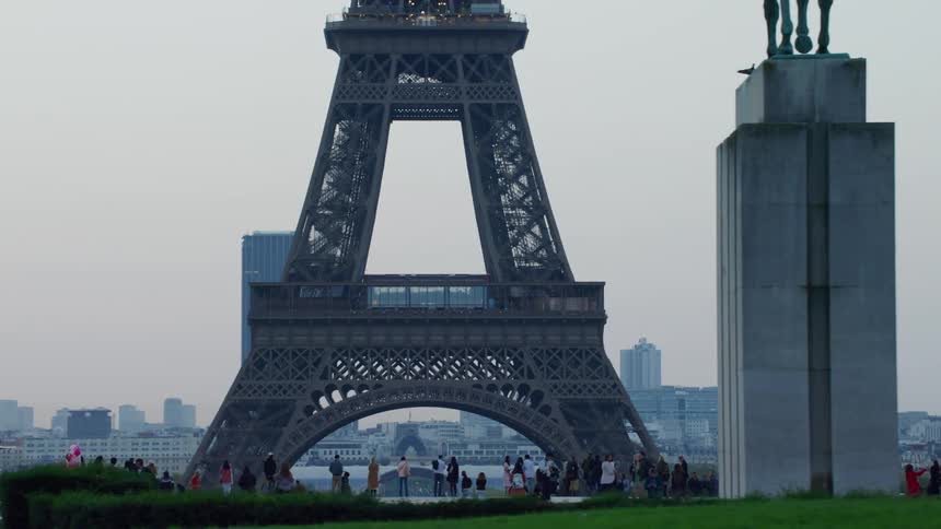 Crowd of people in a square facing the eiffel tower in daylight