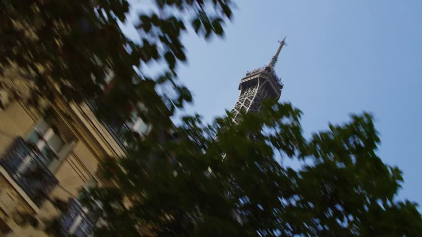 The eiffel tower rises over a row of buildings