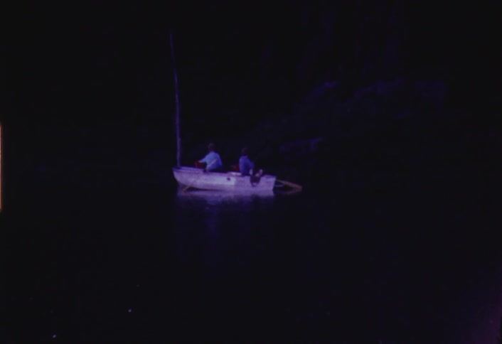 Two people on a small boat at sunset