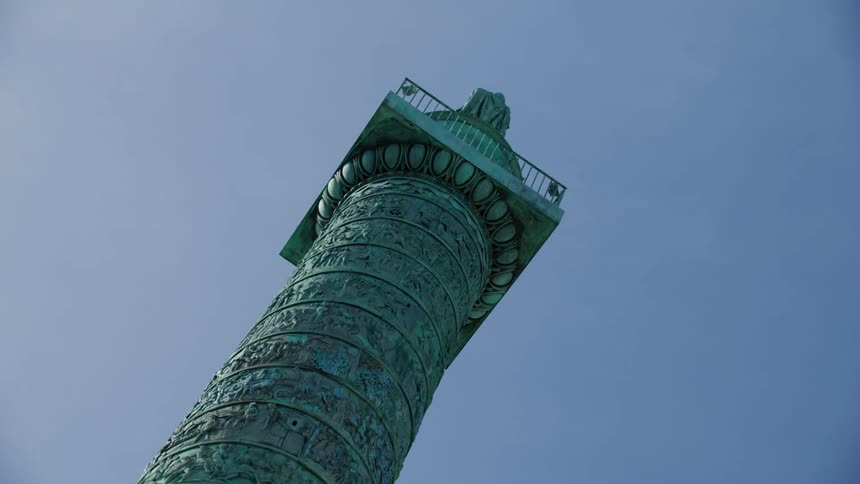 Upward view of a greenish artistic tower on a blue sky day