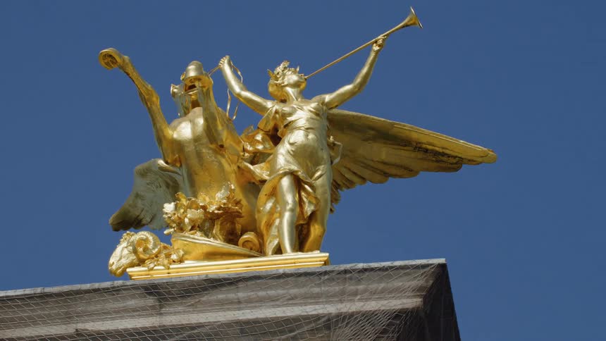A gold statue is under the clear sky