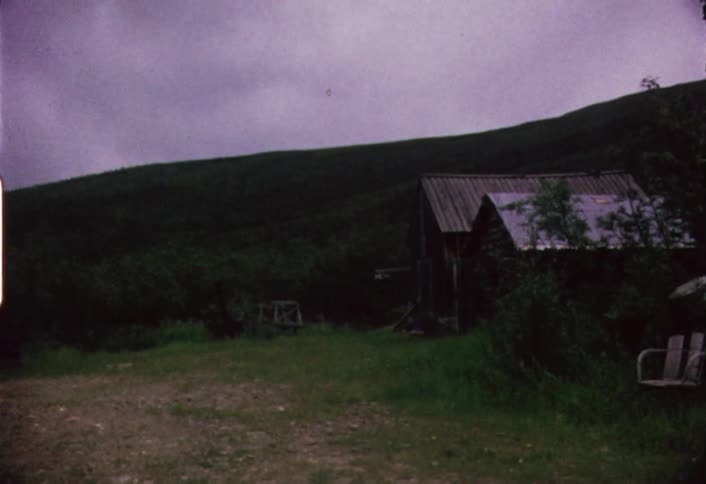 Small structures in the foreground  with dark clouds hovering over mountains