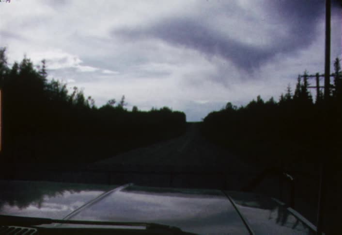 Car driving down a road on cloudy evening