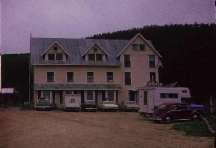 An assortment of vehicles are parked outside a large residential building