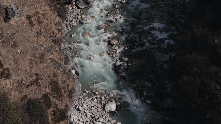 Aerial view of a flowing river amidst rocks