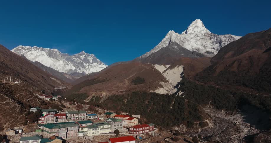 Village on a mountain surrounded by other mountains covered by lines in a way of