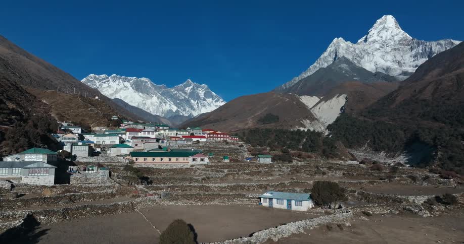 Village pn a mountain surrounded by other mountains covered