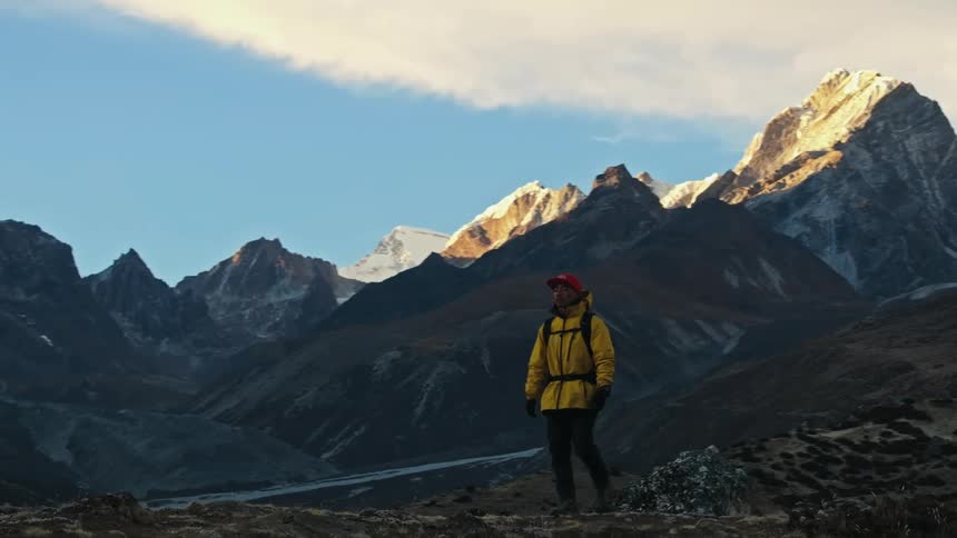 A man walking through the mountain valley during the cold day
