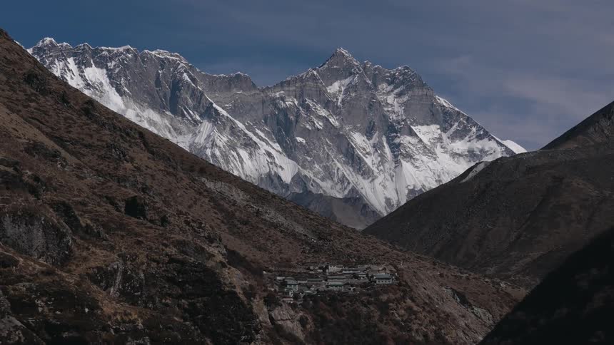 A mountain range is shown with brown and white mountains