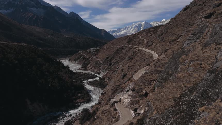 An aerial view of a mountain with a river running at its base