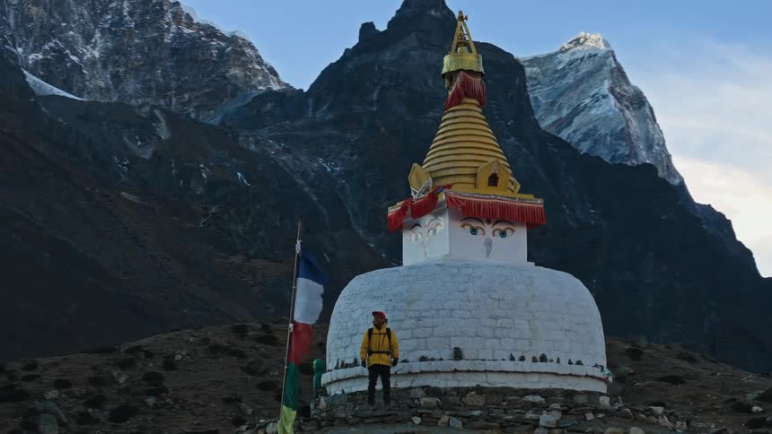 Two people on top of a mountain with a religious temple