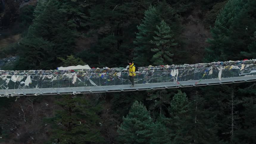 A man walking across a bridge
