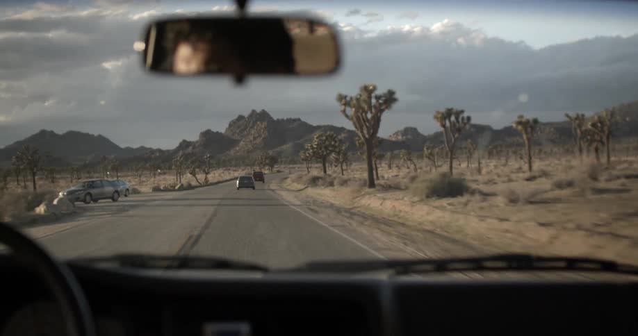 Man driving down a road in the desert