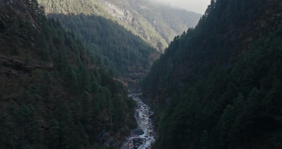 A river snakes through a narrow mountain valley