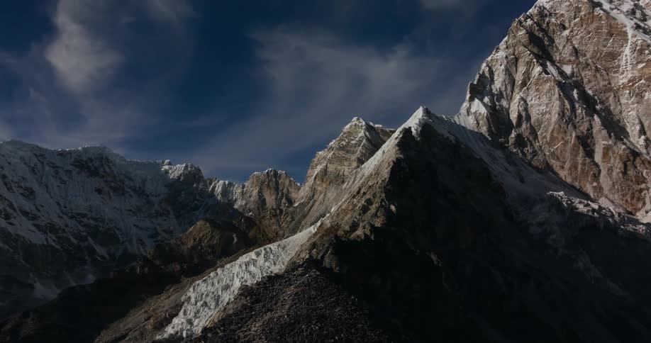Multiple mountain peaks are seen within a snowcapped mountain range