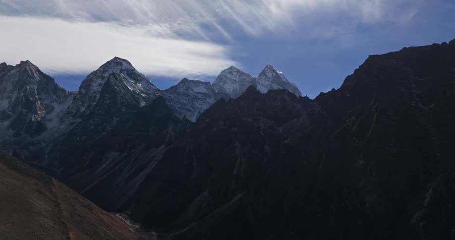 Clouds move over a tall mountain range