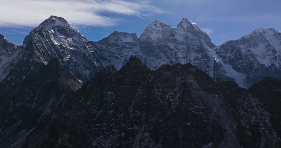 Panorama of mountain ranges with peaks covered by snow in daylight
