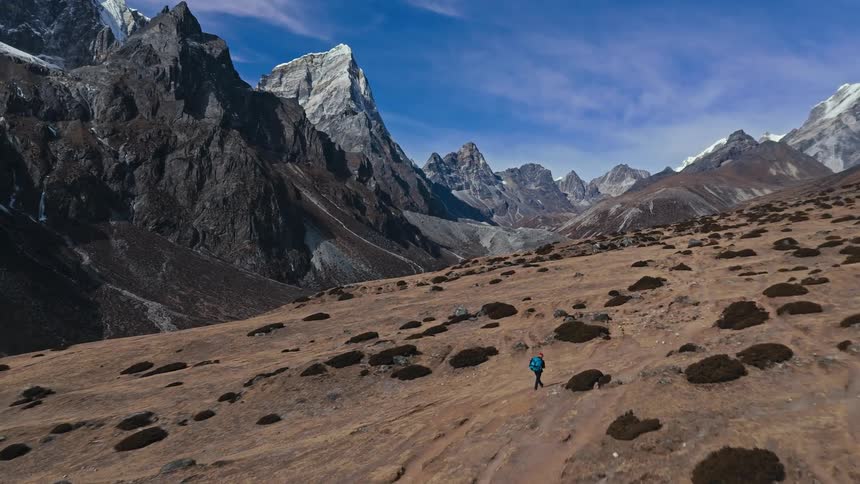 Two hikers walk a plateau never enormous mountains