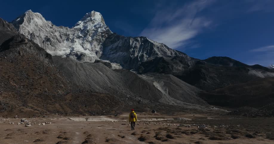 A hiker walks across a mountain valley