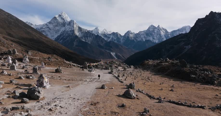 Aerial of a person walking in a mountain valley on a cold day