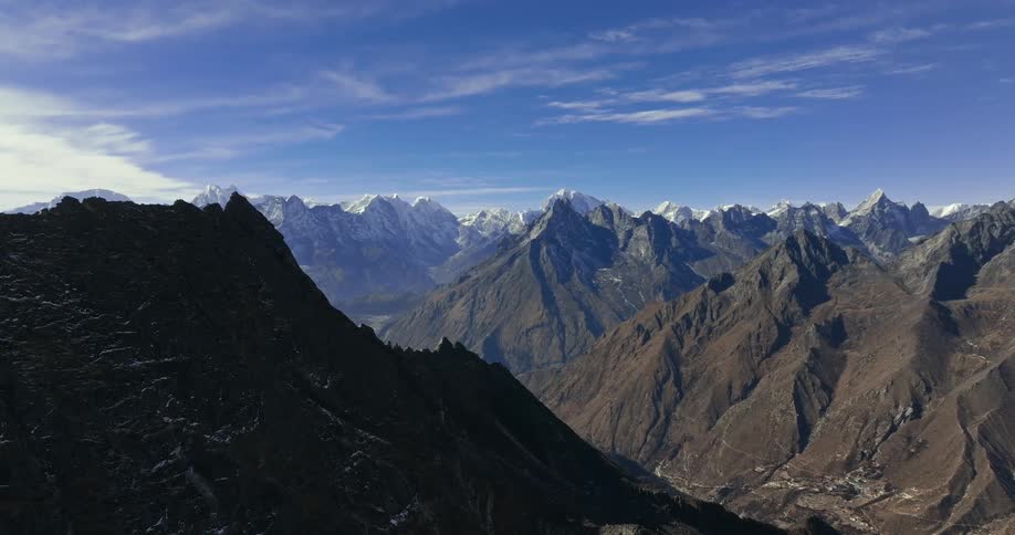 A large mountainous region with huge mountains and some of them have frozen peaks