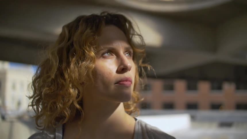 Sunlight shines on a woman's face as she looks upwards