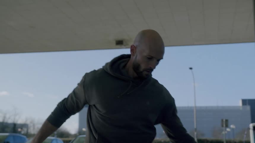 A bald man kicks a soccer ball around