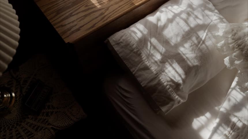 A white pillow on a bed in an organized room