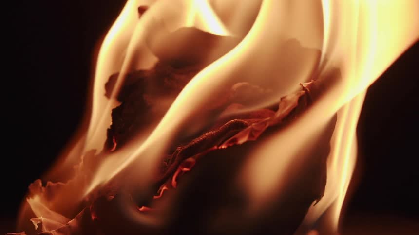 Piece of paper on fire with flames in slow motion