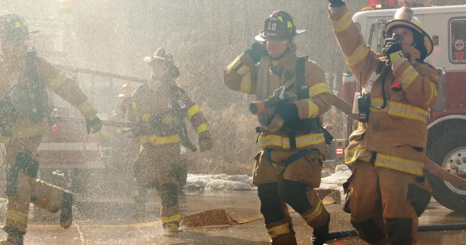 A lot of firefighters running toward a building