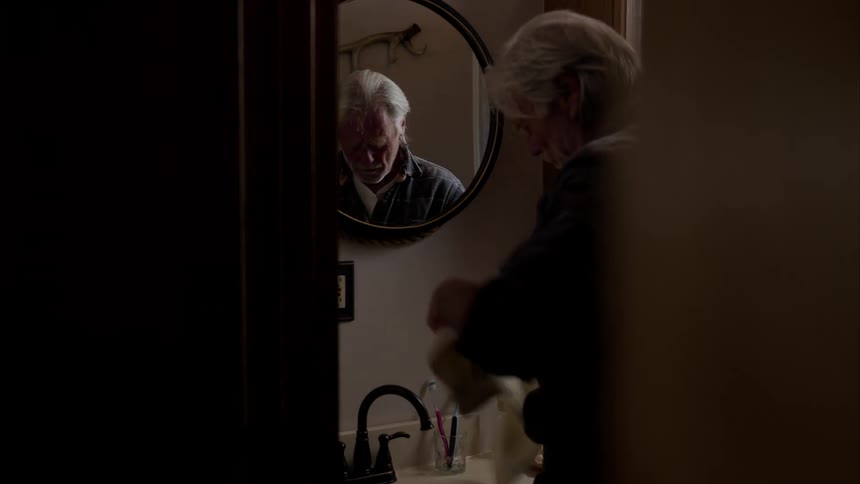 A man washes his face in the bathroom