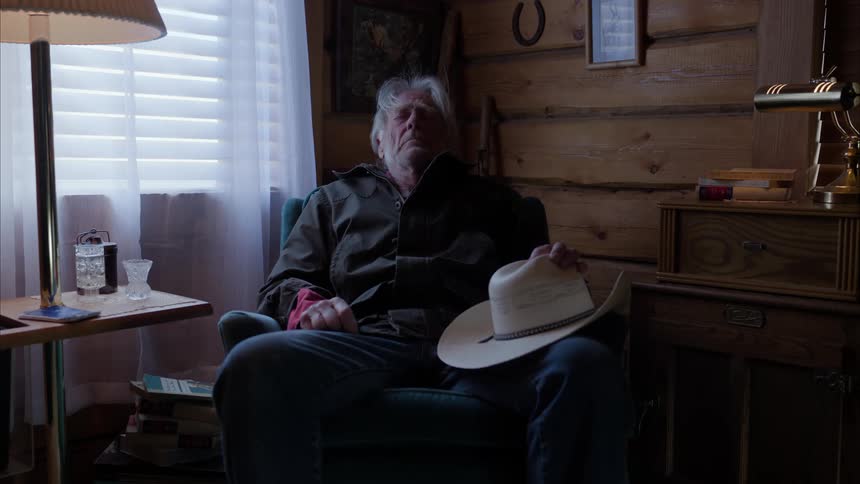 A tired man sitting in an armchair in the corner of the room