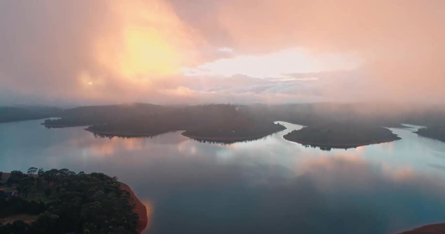 A cloudy sky over a forested coastal area