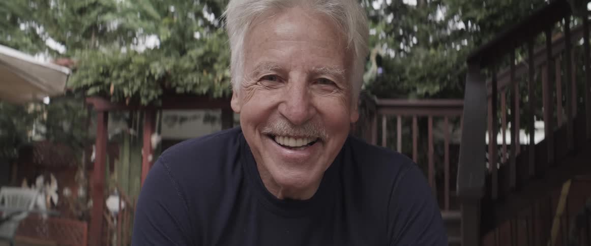 Close up of a happy smiling elderly man in the backyard