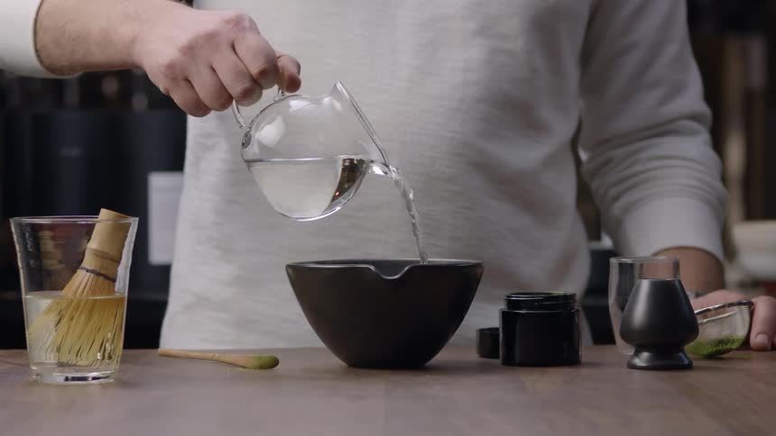 A white man pours water into a bowl