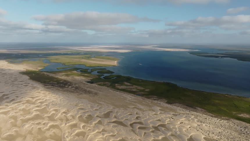 A coastal area with grasslands and a desert nearby