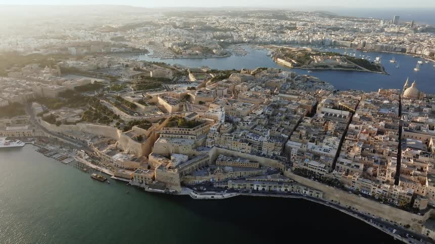 A coastal european city is packed full of numerous buildings