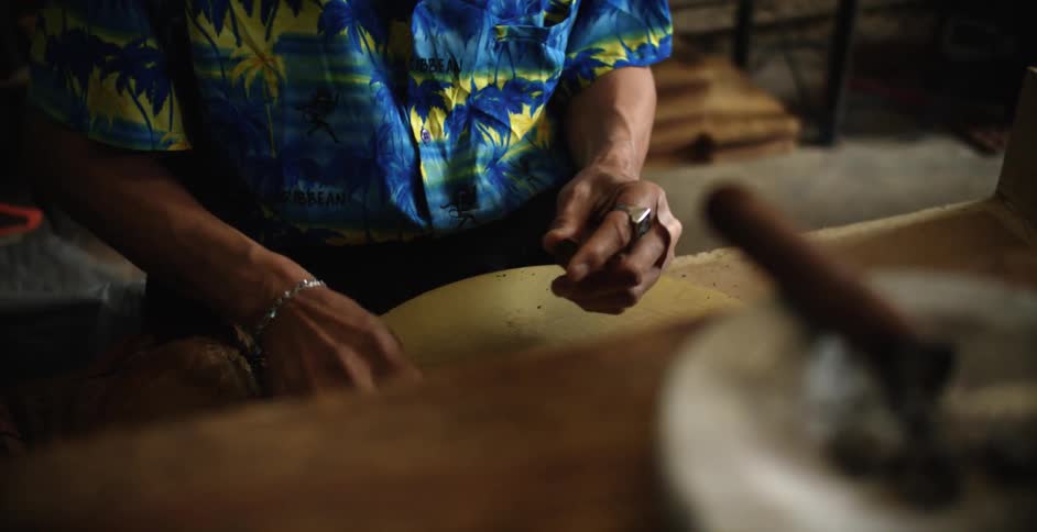 A man rolls a cigar