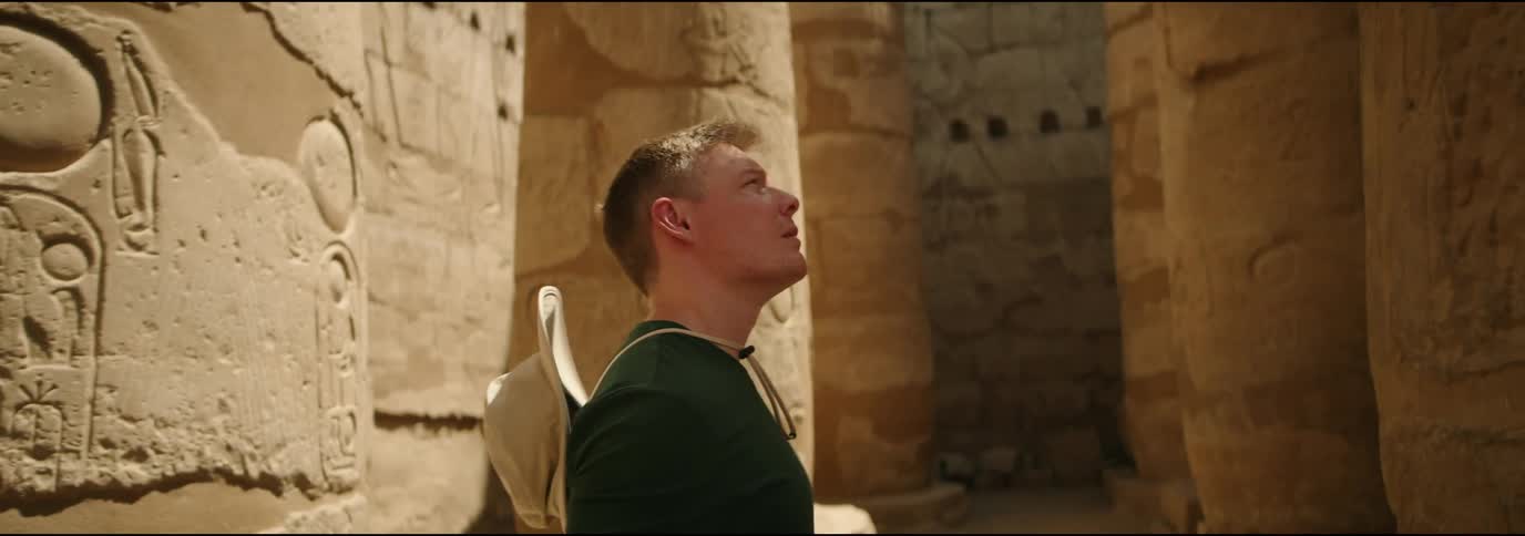 A man contemplating an egyptian historical monument during the day