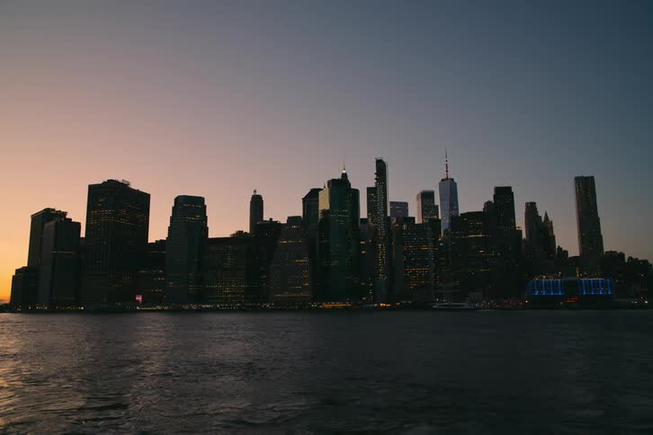 A boat moves by a city on a coast