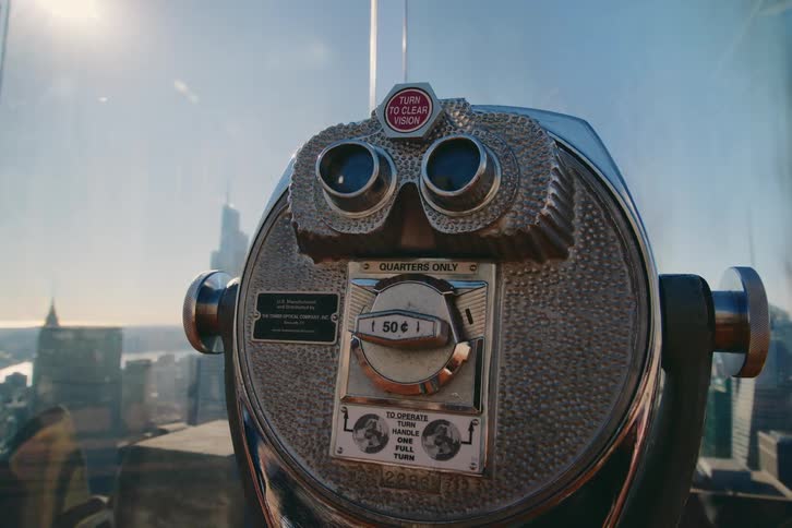 Closeup on a telescopic handle on a building with a panoramic view of a metropolis