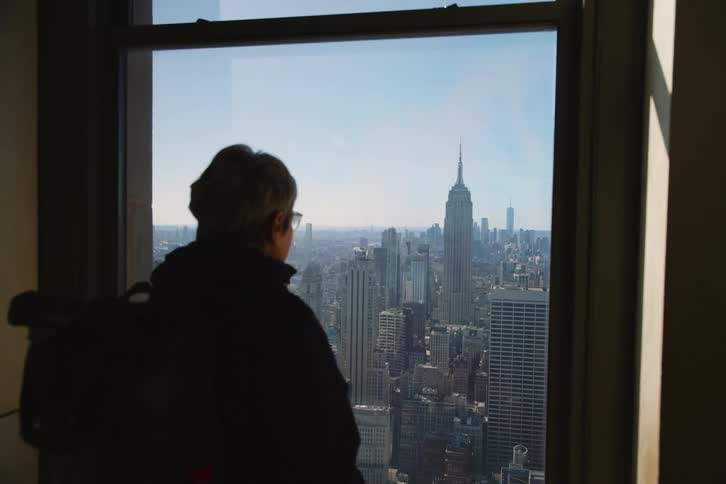 A woman looking out a window of a city