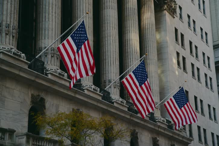 The wind blows the american flags on the building