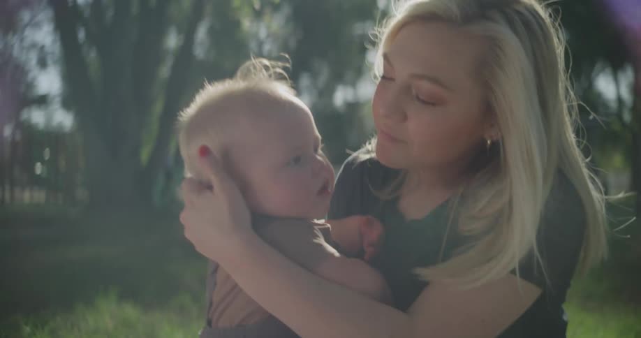 A mother is holding her son in the park