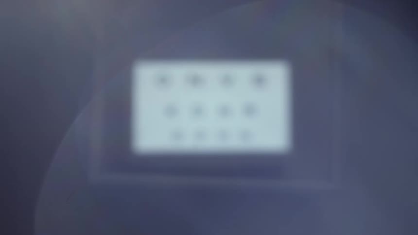 A digital screen shows an eye chart with three lines of letters