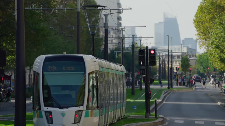 A tram going down the middle of a city road