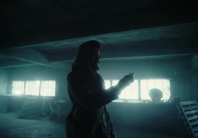 A man holding a metal object inside an abandoned building